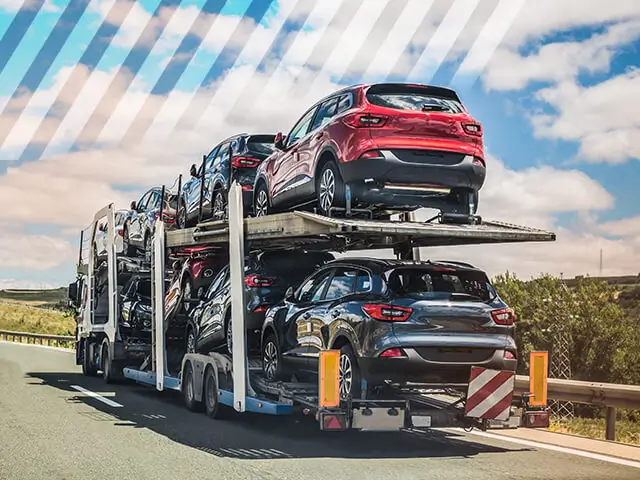 A car carrier truck transporting several cars in a sunny day