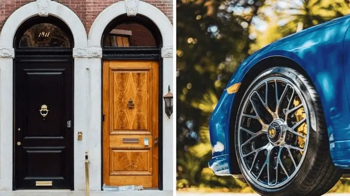 A blue car is parked in front of two closed wooden doors. One dark brown, the other brown.