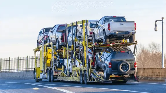 industrial grade yellow classic bonnet car hauler semi truck transporting cars on two levels