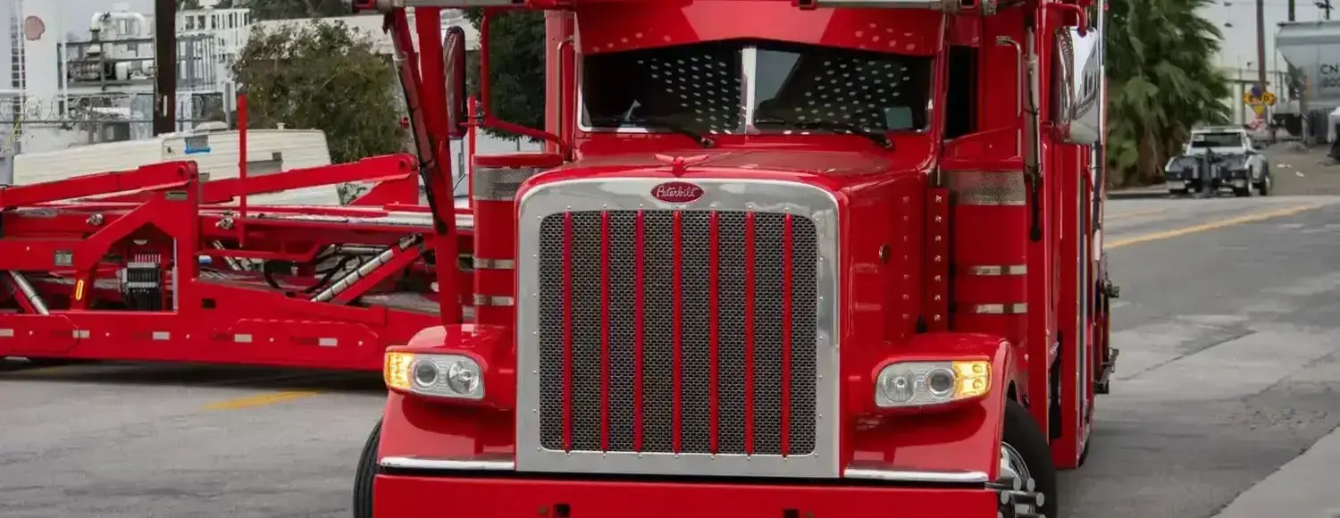 Image of Peterbilt 389 car hauler driving down a street.