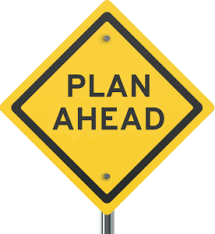 Yellow diamond-shaped traffic sign with �PLAN AHEAD� inscription, mounted on a metal pole, symbolizing strategic foresight.