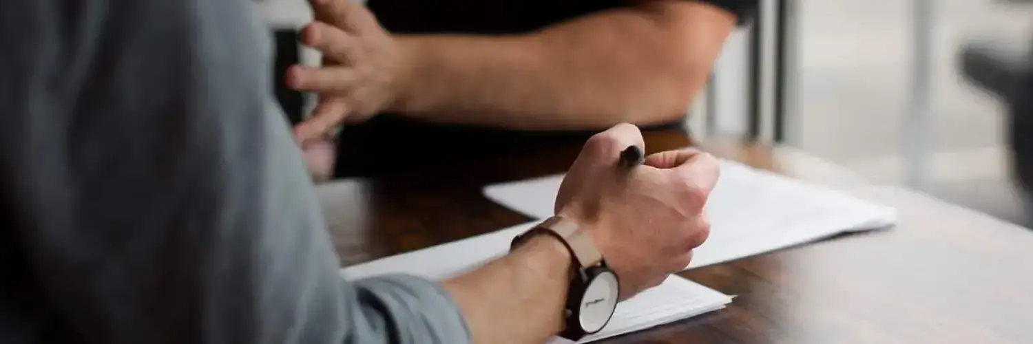 A person signing a paper document.