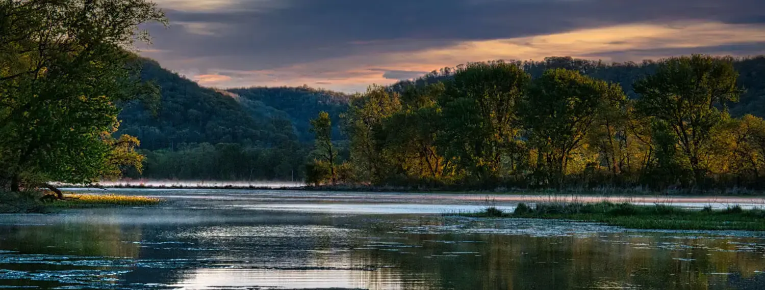 A wide shot of a body of water in Mississippi, possibly a lake, with trees lining the shore.