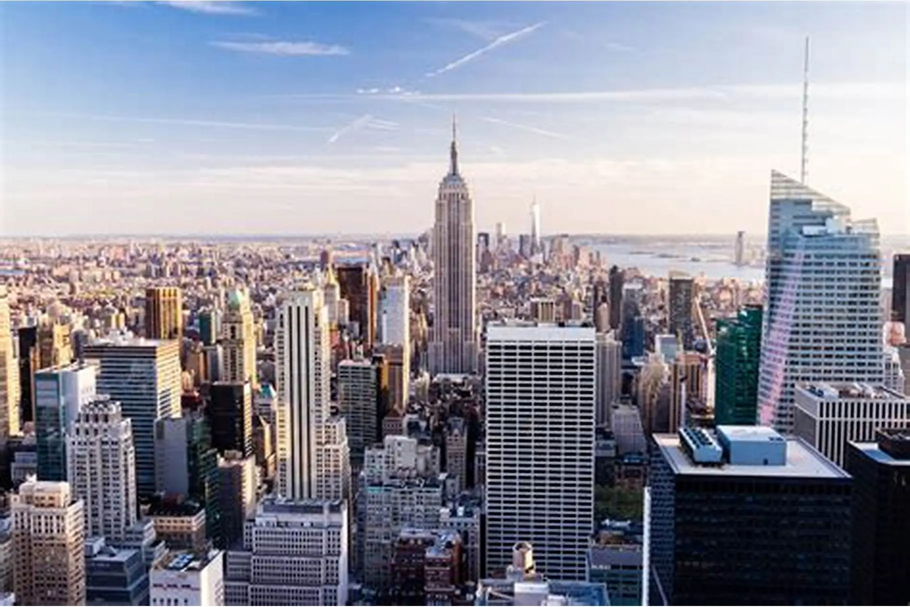 An aerial view of the Manhattan skyline in New York City, showing skyscrapers clustered together.